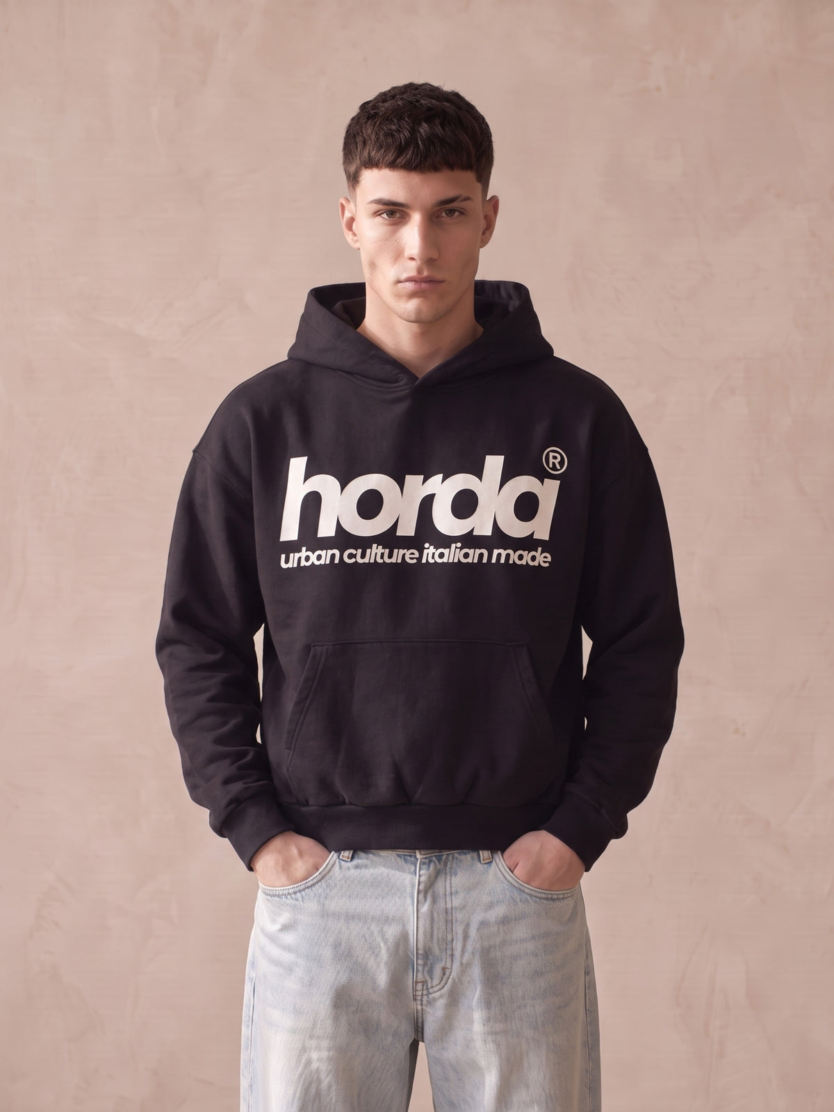 Felpa con cappuccio nera boxy fit Horda con scritta bianca "horda urban culture italian made" sul davanti, indossata con jeans chiari