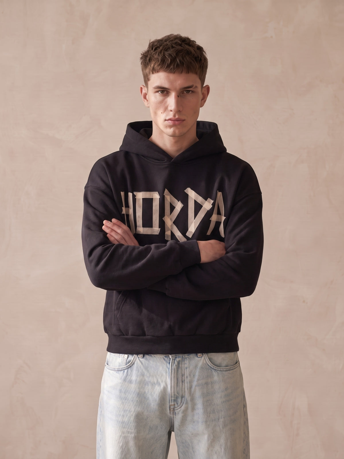 Felpa con cappuccio nera oversize con scritta HORDA effetto nastro adesivo sul davanti, modello a braccia conserte