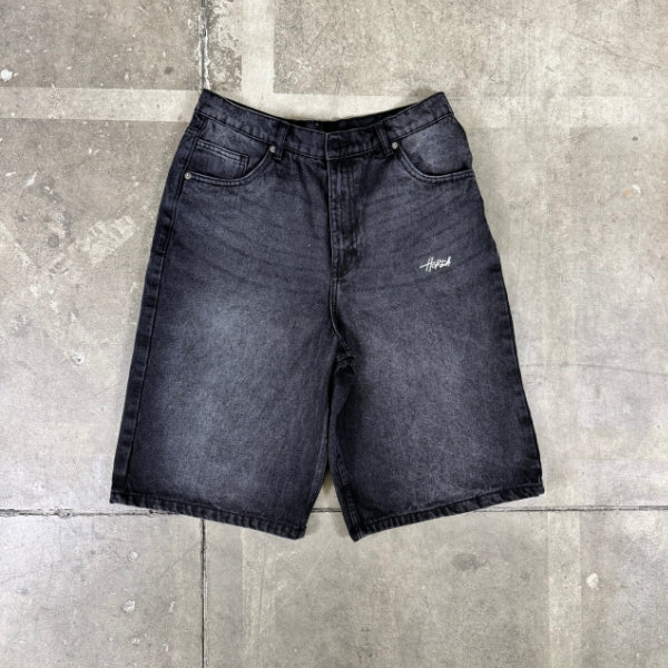 Jeansshorts über verwaschenem Schwarz