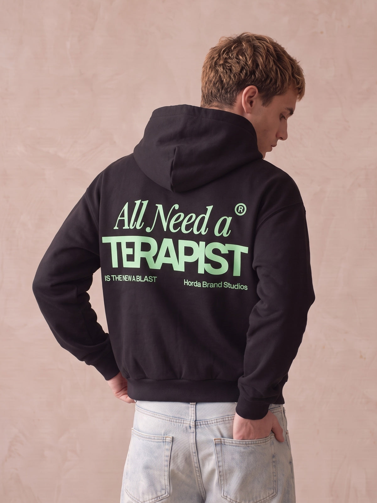 Retro di felpa nera con cappuccio con stampa verde menta "All Need a Terapist", modello di tre quarti