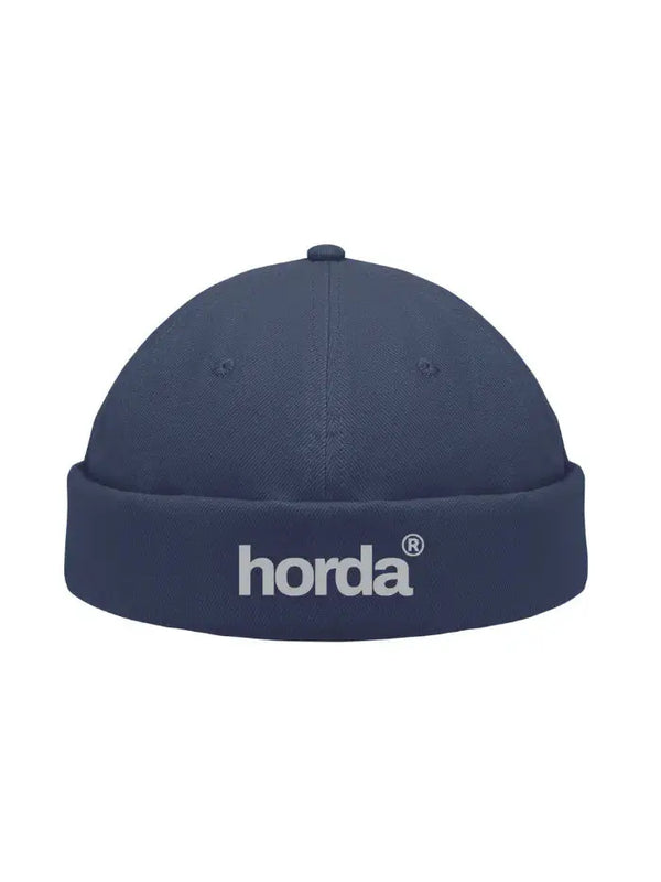 Berretto docker blu navy Horda con logo horda ricamato sul risvolto, still life su sfondo bianco.